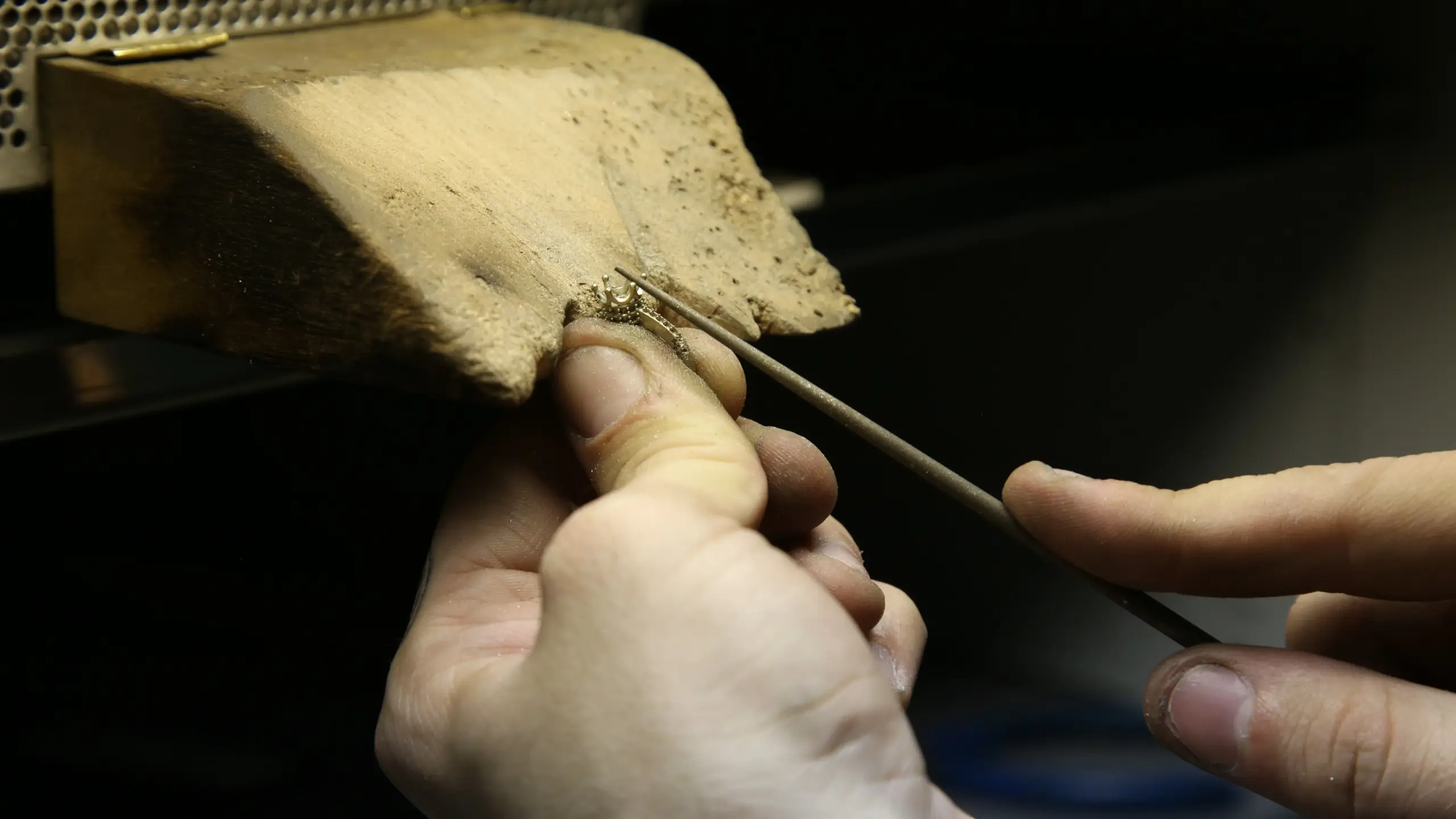 Orafo mentre incassa una pietra preziosa a mano su un gioiello in laboratorio